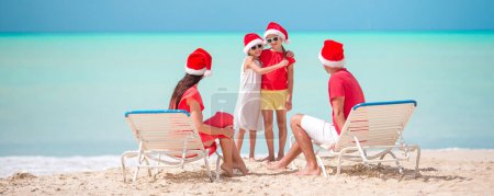 Téléchargez les photos : Famille heureuse avec deux enfants à Santa Hat en vacances d'été - en image libre de droit