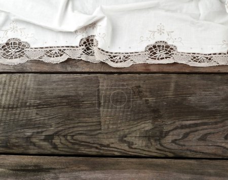 Foto de Toalla de encaje textil de cocina blanca doblada sobre una mesa de madera gris - Imagen libre de derechos