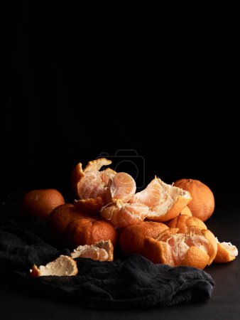 Téléchargez les photos : Pile de mandarine mûre orange sur une table noire - en image libre de droit