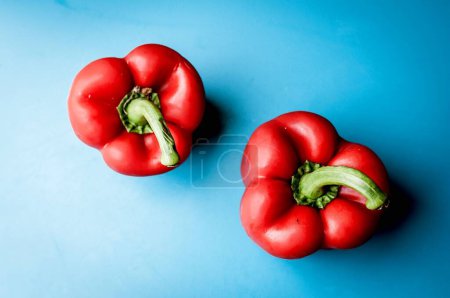 Photo for Two red healthy peppers on blue background - Royalty Free Image