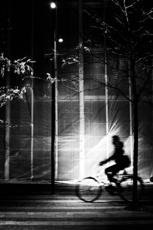 Foto de Imagen de alto contraste de la silueta del hombre en bicicleta en desenfoque movimiento - Imagen libre de derechos