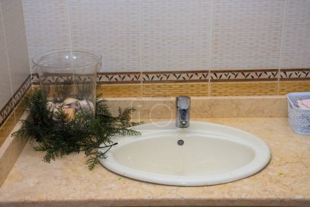 Téléchargez les photos : Salle de bain ouverte lavabo dans la maison avec tuile, et bol de coquillages - en image libre de droit
