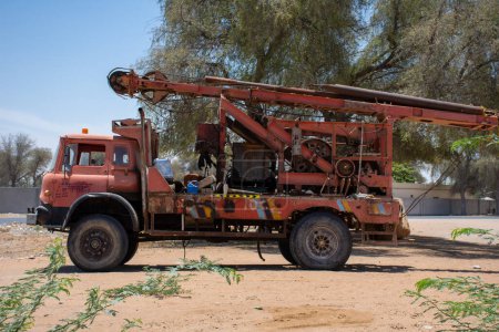 Téléchargez les photos : Un grand vieux camion de machine à eau décomposé rouge stationné - en image libre de droit