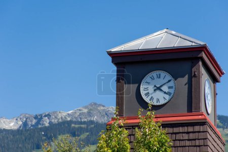 Photo for Roman Numeral Clock Tower with rocky mountains and blue sky - Royalty Free Image