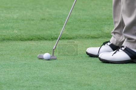 Photo for Player putting golf ball on a green grass - Royalty Free Image