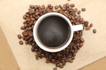 Photo for Cup of coffee with roasted coffee on burlap sack - Royalty Free Image