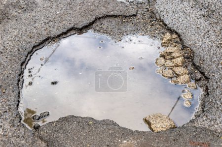 Photo for Large rounded pothole filled with water in Montreal - Royalty Free Image