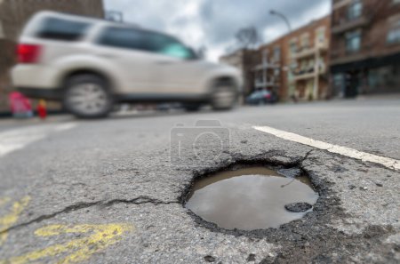 Photo for Large unrepaired pothole on Laurier street in Montreal, Canada - Royalty Free Image