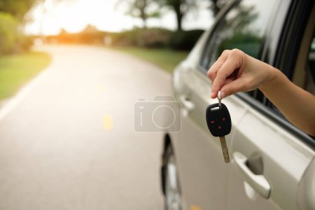 Foto de Mujer mano sosteniendo la llave del coche al coche en el fondo - Imagen libre de derechos