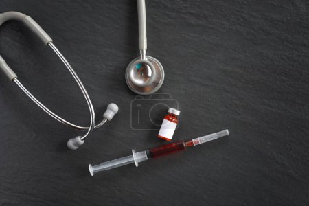 Photo for "stethoscope and Vaccine and syringe injection on black backgroun" - Royalty Free Image