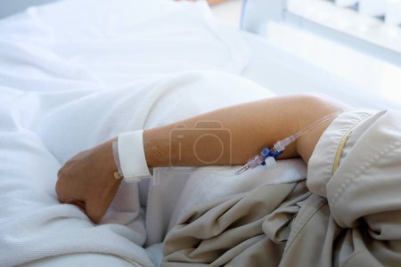 Foto de Primer plano de la mano del paciente en la cama del hospital. - Imagen libre de derechos