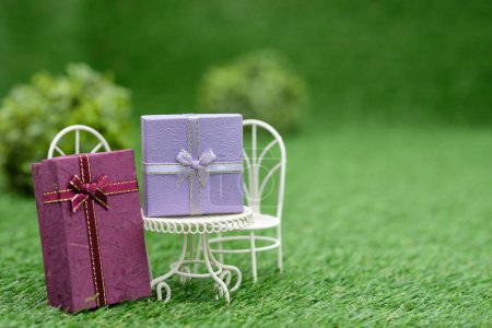 Foto de Cajas de regalo y muebles pequeños en hierba verde - Imagen libre de derechos