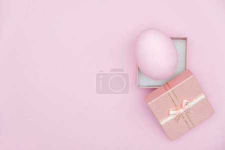Photo for Eggshell with gift box on pink background, top view - Royalty Free Image