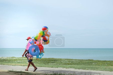 Téléchargez les photos : Vendeur de ballons en bord de mer - en image libre de droit