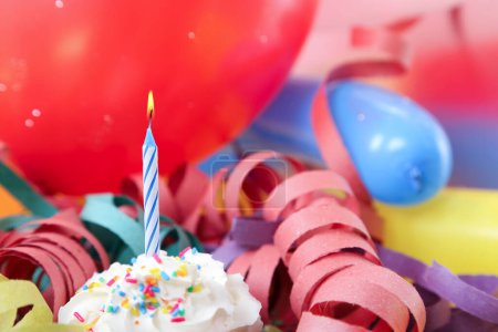 Photo for Birthday cupcake with candle and colorful balloons. - Royalty Free Image
