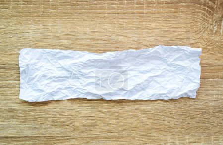 Téléchargez les photos : "Texture abstraite de papier froissé blanc sur fond de table en bois" - en image libre de droit