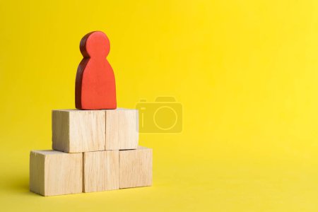 Téléchargez les photos : "Figurine en bois rouge Se tenir sur la pile de bois dans la gestion des ressources humaines" - en image libre de droit