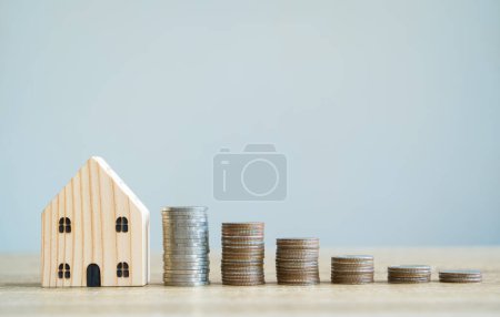 Foto de "Conceptos de ahorro. Modelos de casa de madera con monedas apiladas i" - Imagen libre de derechos