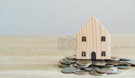 "Concepts d'épargne. Modèles de maison en bois avec des pièces de monnaie en attendant"