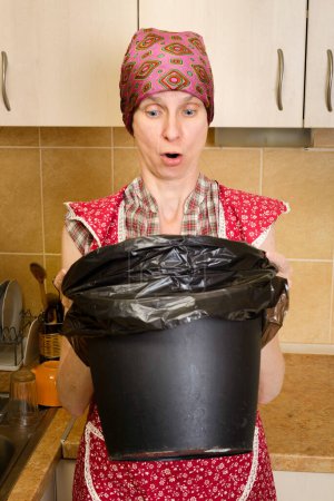 Téléchargez les photos : "Femme regardant à l'intérieur d'une poubelle" - en image libre de droit