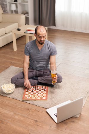 Foto de Hombre en una videollamada jugando ajedrez con amigos - Imagen libre de derechos