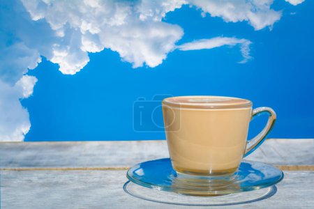 Photo for A cup of hot cappuccino or latte on wooden table and white cloud - Royalty Free Image