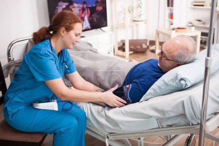 "Krankenschwester überprüft den Blutdruck eines Rentners"