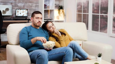 Photo for "Caucasian couple relaxing watching tv in living room" - Royalty Free Image