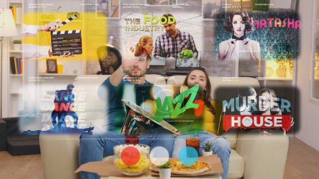 Téléchargez les photos : Couple sur le canapé regardant une projection virtuelle d'une télévision intelligente devant eux - en image libre de droit