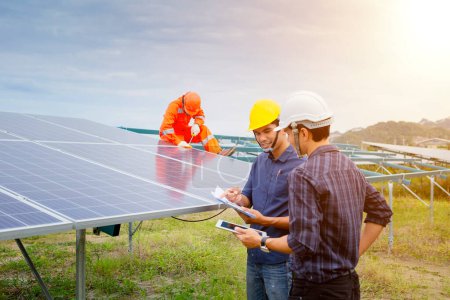 Foto de Ingenieros y trabajadores en uniforme e instala paneles solares sólidos - Imagen libre de derechos