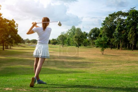 Foto de Hermosa chica jugando al golf en un hermoso campo de golf verde soleado - Imagen libre de derechos