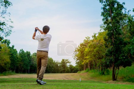 Foto de Hombre jugando golf en hermoso campo de golf verde soleado - Imagen libre de derechos