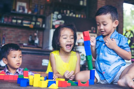 Foto de Niños jugando con bloques de madera de colores - Imagen libre de derechos