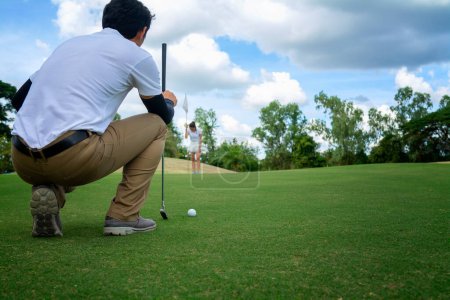 Foto de Jugador de golf check line para poner pelota de golf en hierba verde - Imagen libre de derechos