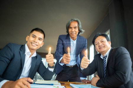 Téléchargez les photos : Les trois hommes d'affaires qui lèvent le pouce indiquent le succès - en image libre de droit