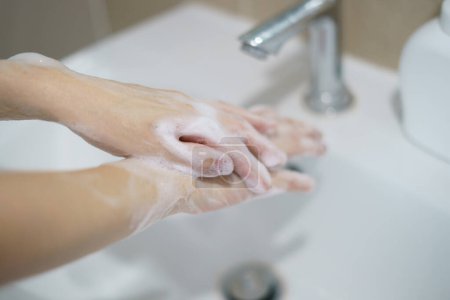 Téléchargez les photos : Se laver les mains avec du savon. Pour tuer les germes, bactéries et virus. - en image libre de droit