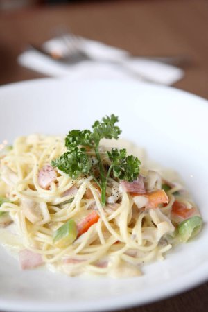 Téléchargez les photos : "Spaghetti aux champignons et sauce au jambon blanc sur fond de bois" - en image libre de droit