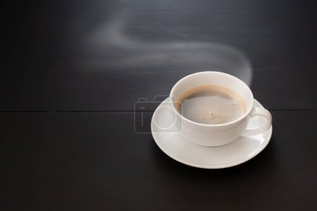 Foto de Tazas de café de cerámica blanca y granos de café sobre una mesa de madera negra - Imagen libre de derechos