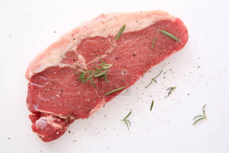 Téléchargez les photos : "Steak de bœuf cru frais au poivre et romarin isolé en blanc
 " - en image libre de droit