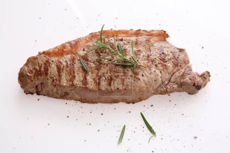 Photo for "Grilled Beef Steak with pepper and rosemary isolated in white ba" - Royalty Free Image