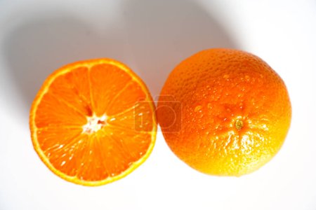 Foto de "Una naranja en rodajas sobre un fondo blanco liso
" - Imagen libre de derechos