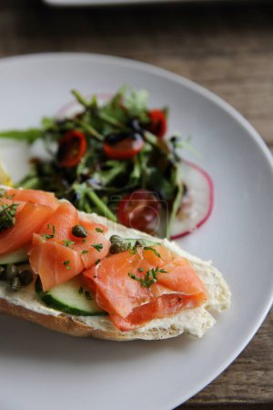 Photo for "smoked salmon on toasted bread with cream fresh, lemon and salad" - Royalty Free Image
