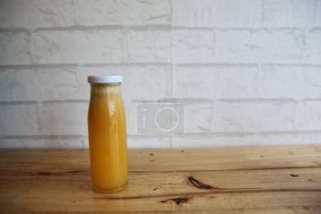 Photo for Orange Mix fruit juice in bottle on wooden table - Royalty Free Image