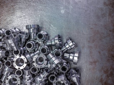 Photo for "Shiny steel parts after cnc turning, drilling and machining on steel surface with selective focus." - Royalty Free Image