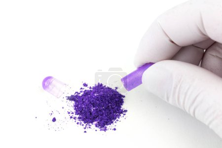 Téléchargez les photos : "main dans le gant médical ouverture proton violet couleur bio med capsule isolé sur fond blanc gros plan" - en image libre de droit