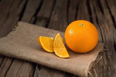Téléchargez les photos : Tranches fraîches d'orange et d'orange groupe sur une table en bois sombre - en image libre de droit