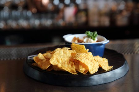 Téléchargez les photos : Gros plan de chips avec sauce sur une table noire - en image libre de droit