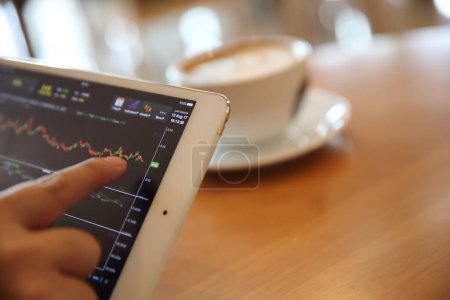 Téléchargez les photos : Business Hand Analyse Stock Finance Graphique sur tablette avec café - en image libre de droit