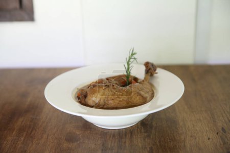 Foto de Coq au vin, pollo cocido en vino tinto con zanahorias y patatas - Imagen libre de derechos