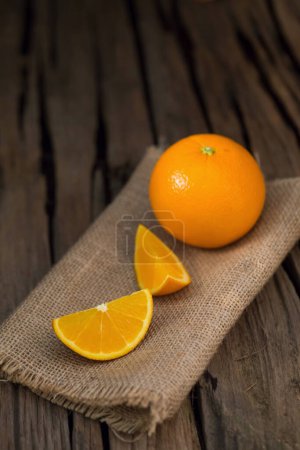 Photo for Fresh orange and orange slices group on a dark wooden table - Royalty Free Image